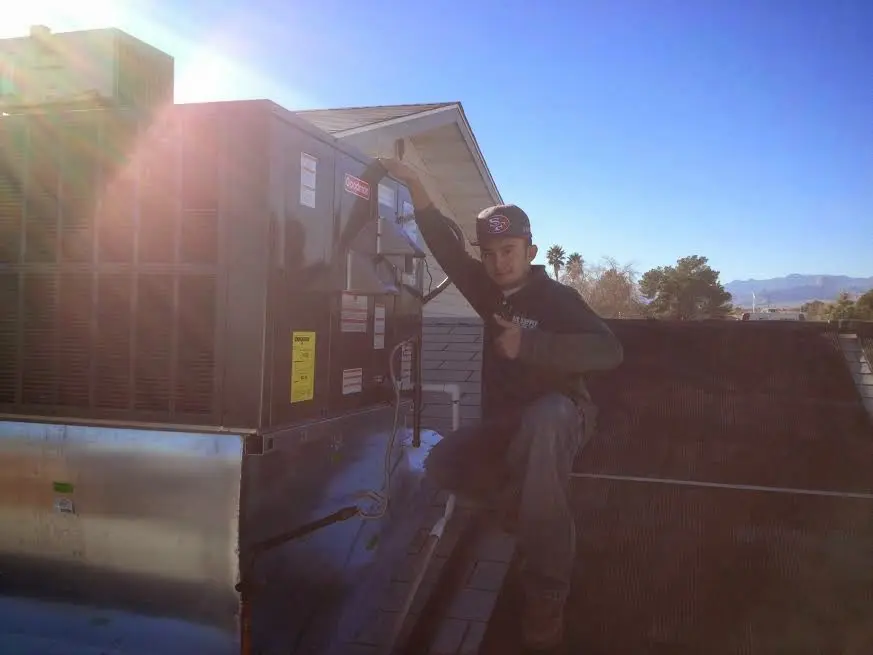 HVAC technician performing AC Tune-Up on a rooftop unit in Hawthorne